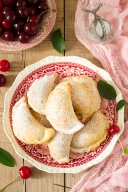Turta ile kiraz, pudra şekeri ve meyveleri taze Kiraz ahşap yüzeye serpilir. Seçici odak.