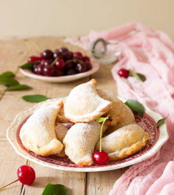 Turta ile kiraz, pudra şekeri ve meyveleri taze Kiraz ahşap yüzeye serpilir. Seçici odak.