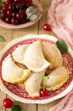 Turta ile kiraz, pudra şekeri ve meyveleri taze Kiraz ahşap yüzeye serpilir. Seçici odak.