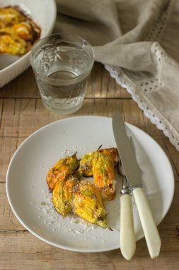 Ricotta ve maden suyu bir bardak pişmiş kabak çiçekleri hizmet peynir ile doldurulmuş. Rutik stil, seçici odak.