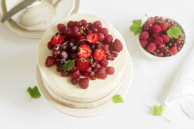 Yaz ev bisküvi kek lor kremalı taze çilek, çilek, ahududu ve kuş üzümü ile dekore edilmiş.