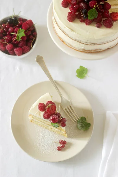Літній домашній бісквітний торт з сирним кремом, прикрашений свіжими ягодами полуниці, малини та смородини . — стокове фото
