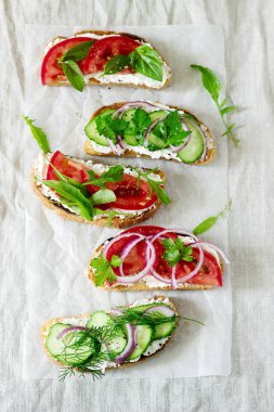 Bruschetta veya sandviç krem peynir, domates, salatalık ile dekore edilmiş yeşillik ile.