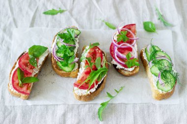 Bruschetta veya sandviç krem peynir, domates, salatalık ile dekore edilmiş yeşillik ile.