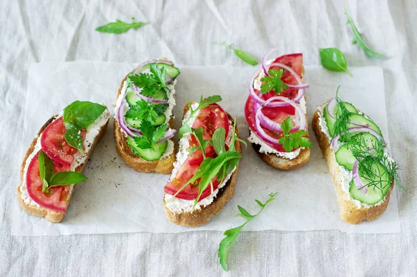 Bruschetta lub kanapki z pomidory, ogórki, ser, ozdobione Zieloni. — Zdjęcie stockowe