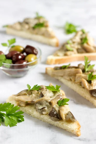 Треугольные сэндвичи с летними грибами, приготовленные со сливками и травами, подаваемые с оливками . — стоковое фото