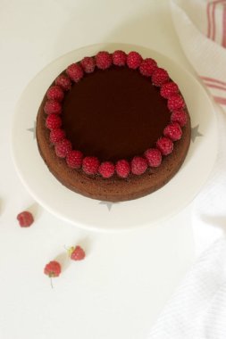 Çikolatalı browni kek ahududu ve hafif bir arka plan üzerine çikolata krema. Seçici odak.