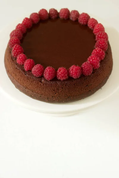 Шоколадний пиріг з малиною та шоколадною глазур'ю на світлому фоні . — стокове фото