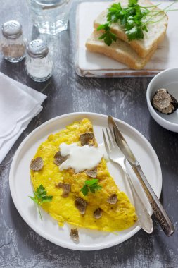 Omlet trüf ve maydanoz, ekşi krema, ekmek ve bir bardak taze su ile görev yaptı. Seçici odak.