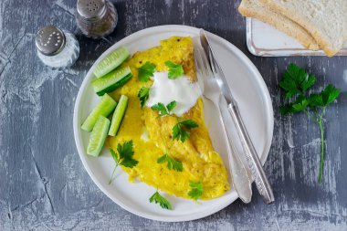 Omlet ile maydanoz, ekşi krema ve taze salatalık ile servis edilir. Seçici odak.