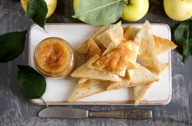 Bir cam kavanoza ekmek tost ve bir ahşap yüzeyde olgun elma ile elma reçel. Rustik tarzı, seçici odak.