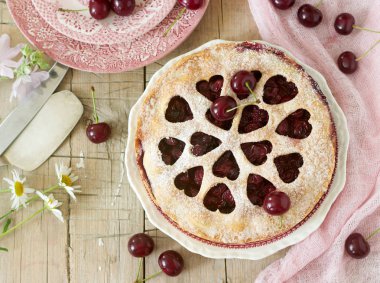 Kirazlı turta kalp şeklinde süsleme çay, bir buket çiçek ve olgun kiraz meyveleri ile bir fincan ile dekore edilmiştir. Vintage tarzı, seçici odak.