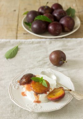 Karamelize Erik ve ahşap arka plan üzerinde olgun erik ile dondurma. Rustik tarzı, seçici odak.