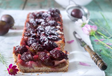 Tatlı pasta karamelize Erik ve ahşap bir masa üzerinde olgun erik ile kısa pasta dan. Rustik tarzı, seçici odak.