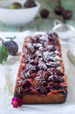 Tatlı pasta karamelize Erik ve ahşap bir masa üzerinde olgun erik ile kısa pasta dan. Rustik tarzı, seçici odak.