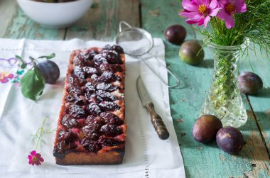 Tatlı pasta karamelize Erik ve ahşap bir masa üzerinde olgun erik ile kısa pasta dan. Rustik tarzı, seçici odak.