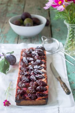 Tatlı pasta karamelize Erik ve ahşap bir masa üzerinde olgun erik ile kısa pasta dan. Rustik tarzı, seçici odak.