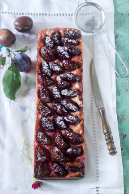Tatlı pasta karamelize Erik ve ahşap bir masa üzerinde olgun erik ile kısa pasta dan. Rustik tarzı, seçici odak.