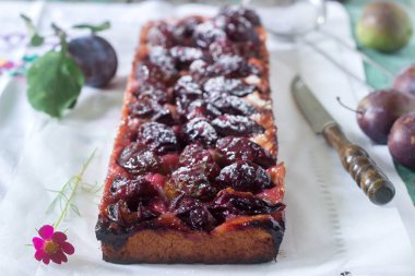Tatlı pasta karamelize Erik ve ahşap bir masa üzerinde olgun erik ile kısa pasta dan. Rustik tarzı, seçici odak.