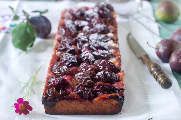 Tatlı pasta karamelize Erik ve ahşap bir masa üzerinde olgun erik ile kısa pasta dan. Rustik tarzı, seçici odak.