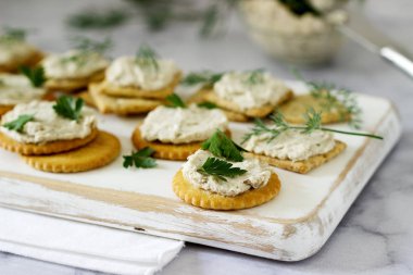 Aperatif kraker ve lor balık Yapıştır otlar üzerinde hafif bir arka plan ile. Seçici odak.