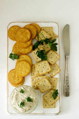 Aperatif kraker ve lor balık Yapıştır otlar üzerinde hafif bir arka plan ile. Seçici odak.