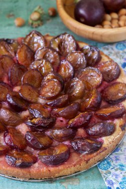 Tatlı pasta karamelize Erik ve ahşap bir masa üzerinde olgun erik ile kısa pasta dan. Rustik tarzı, seçici odak.