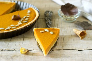 Şükran günü veya ahşap arka plan üzerinde Halloween için geleneksel Amerikan kabak pasta. Rustik tarzı, seçici odak.