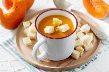 Kabak ve kruton ve hafif bir arka plan üzerinde kabak dilimleri ile hassas bitkisel krem çorbası. Seçici odak.