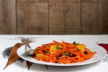 Sulu vitamini havuç salatası portakal, Kuru erik ve fındık. Rustik tarzı, seçici odak.