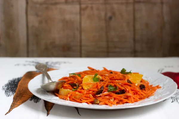 Sulu vitamini havuç salatası portakal, Kuru erik ve fındık. Rustik tarzı, seçici odak.