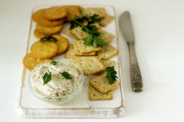 Aperatif kraker ve lor balık hamur hafif bir arka plan üzerinde otlar ile.