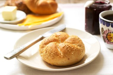 Kaiser rulo, frenk üzümü reçel, tereyağı ve peynir ve çay ile Servis Kahvaltı. Seçici odak.