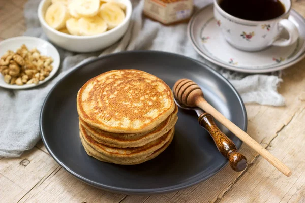 Pfannkuchen mit Banane, Nüssen und Honig, serviert mit Tee. Rustikaler Stil. — Stockfoto