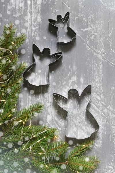 Winter achtergrond met spar takken, garland en cookie cutters op een grijze achtergrond beton. Wenskaart. — Stockfoto