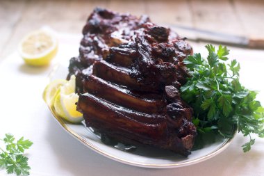 İştah açıcı pişmiş sırlı Dana eti veya domuz kaburga limon ve otlar ile görev yaptı. Seçici odak.