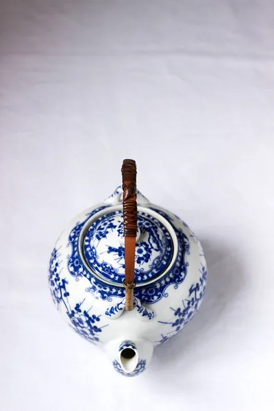 대나무 손잡이와 바탕에 파란색 패턴의 중국어 화이트 도자기 찻주전자 선택적 — 스톡 사진