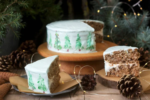 Gâteau de fête décoré d'arbres de Noël peints sur un fond sombre de branches et de cônes. Style rustique . — Photo