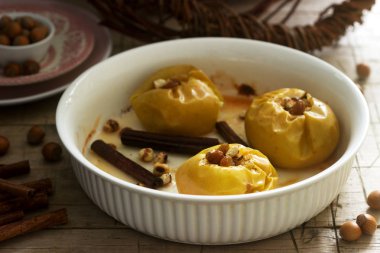 Pişmiş elma kuru üzüm, fındık ve ahşap zemin üzerine tarçın ile karıştırın. Rustik tarzı.