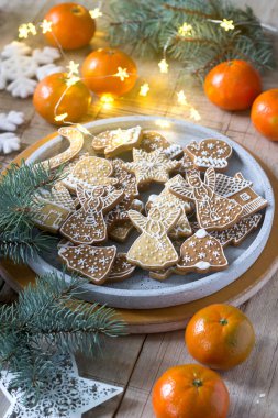 Gingerbread çerezleri mandalina, çam dalları ve çelenk bir kış zemin üzerine beton bir tepsi. Kış kompozisyon, seçici odak.