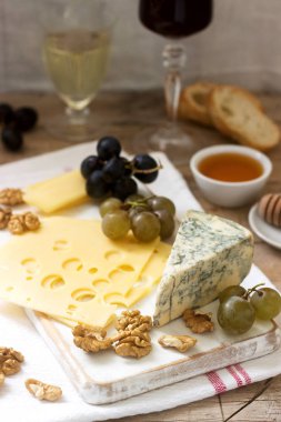 Peynir, üzüm, fındık ve bal, çeşitli türde meze beyaz ve kırmızı şarap servis. Rustik tarzı, seçici odak.