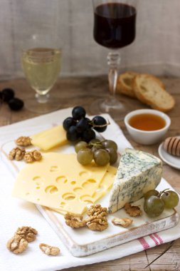 Peynir, üzüm, fındık ve bal, çeşitli türde meze beyaz ve kırmızı şarap servis. Rustik tarzı, seçici odak.