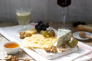 Peynir, üzüm, fındık ve bal, çeşitli türde meze beyaz ve kırmızı şarap servis. Rustik tarzı, seçici odak.