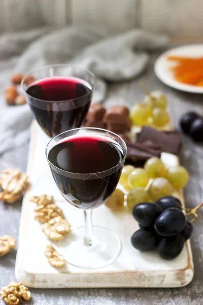 Licor caseiro Creme de Cassis servido com uvas, nozes e chocolate. Estilo rústico . — Fotografia de Stock