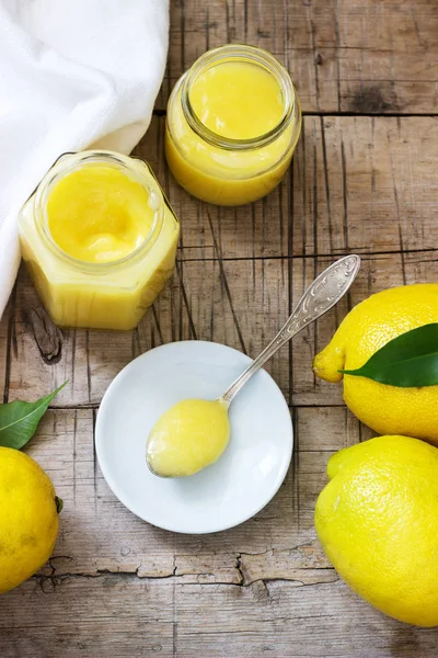 Hausgemachter Zitronenquark mit Gläsern und Zitronen auf Holzuntergrund. rustikaler Stil. — Stockfoto