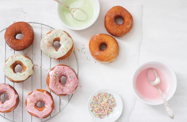 自制的甜甜圈 在浅色的背景上装饰有彩色糖霜和有色糖 选择性对焦 — 图库照片