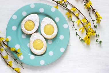 Ev yapımı Paskalya limon çerezler ve hafif bir arka plan üzerinde dallar çiçek açan hor çiçeği. Seçici odak.