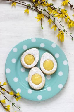 Ev yapımı Paskalya limon çerezler ve hafif bir arka plan üzerinde dallar çiçek açan hor çiçeği.