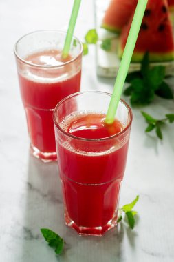 Bir cam bardak ve dilim karpuz hafif bir arka plan üzerine nane ile soğuk karpuz limonata. Seçici odak.