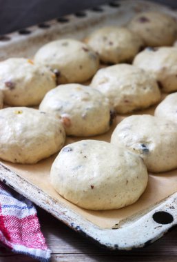 Tepsi çöreği ahşap bir masa üzerinde çapraz pişmemiş yuvarlak fırın. Seçici odak.